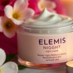 Elemis night cream jar with flowers and candlelight.